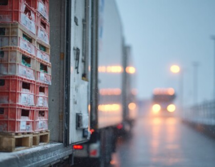 Medium Shot Of Refrigerated Truck Doors Opening Main Focus On Frozen Poultry Crates Stacked Inside Blurred Background Emphasizing Cold Transport Environment.